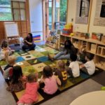 Children at Creative Kids at Carkeek Park enjoy a book reading in preparation for an upcoming field trip to the zoo, as part of their SPP summer extension programming.
