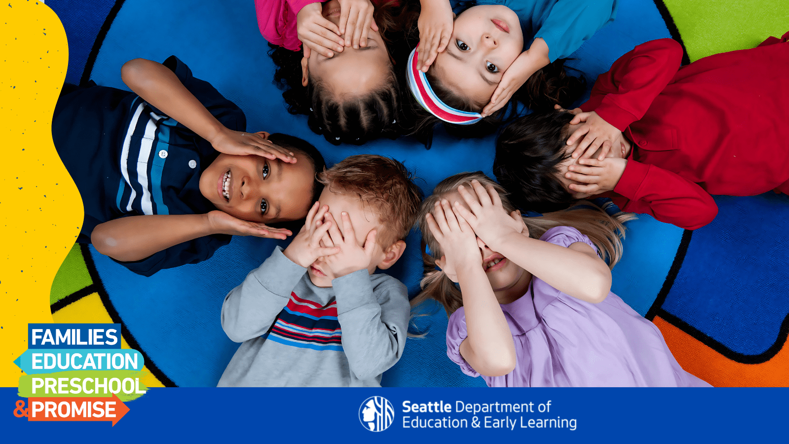 Children in a circle smiling and covering their eyes.