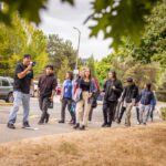 On the left, Seattle Promise Outreach Specialist Aurelio Barajas guides a group of incoming Scholars at South Seattle College for Summer Bridge 2023