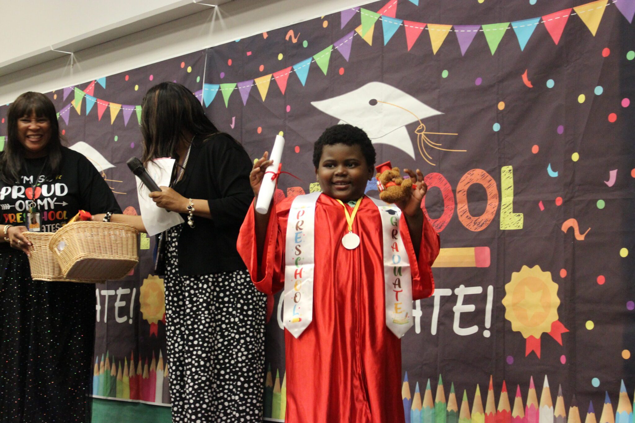 A smiling child wearing a graduation gown.